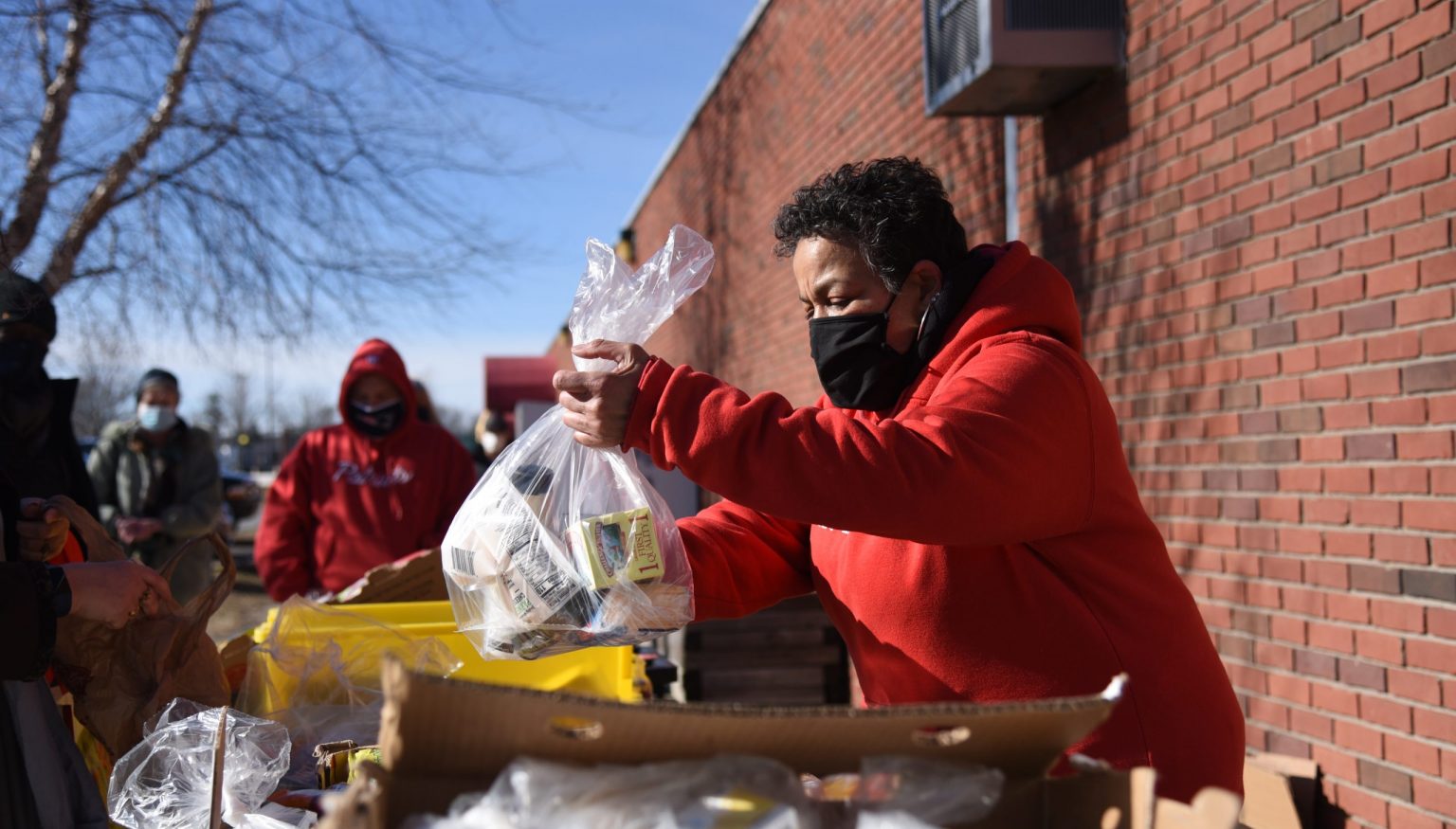Old Colony YMCA employee distributes food to the community